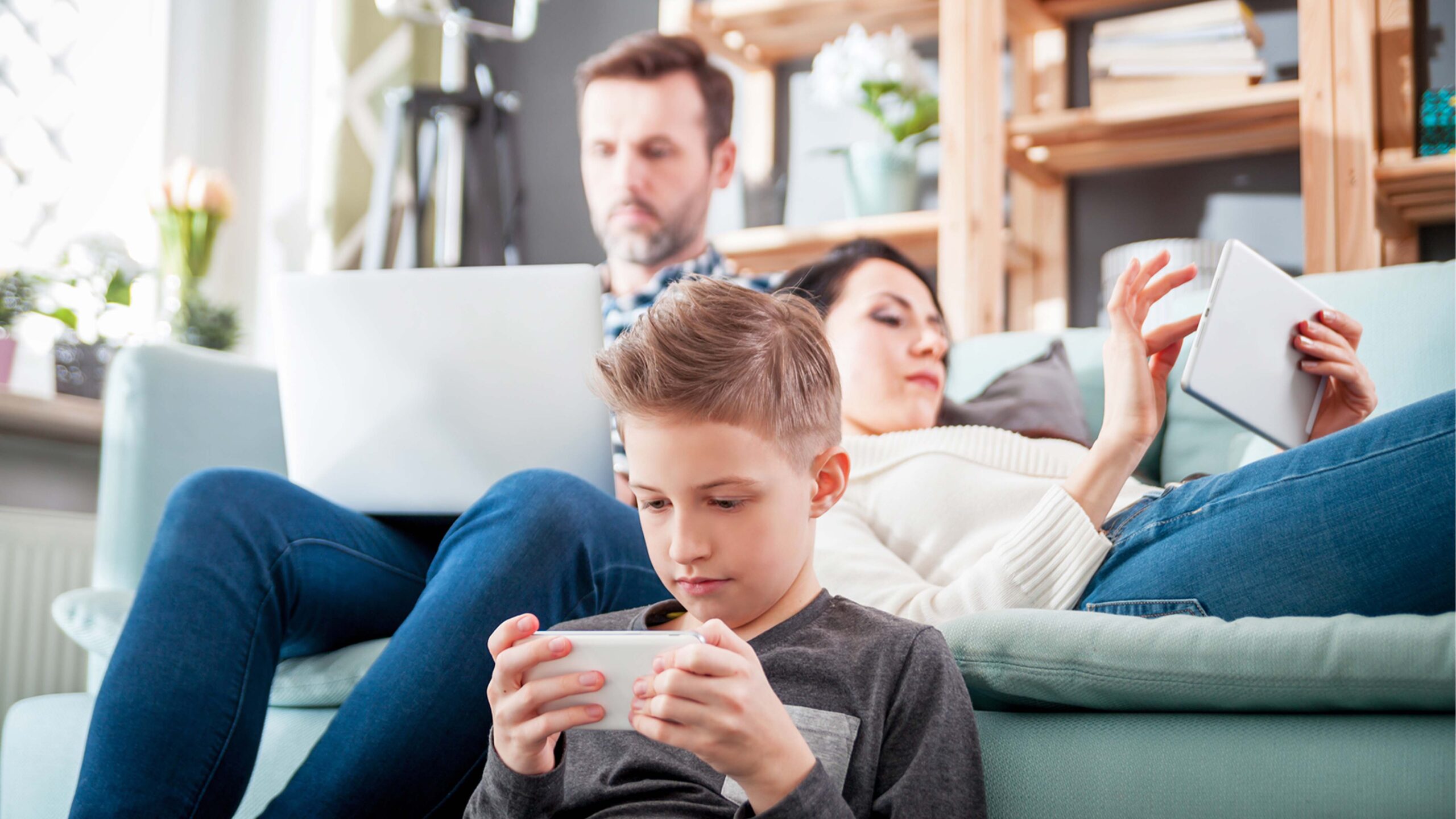 A family on devices - cell phones and laptops.